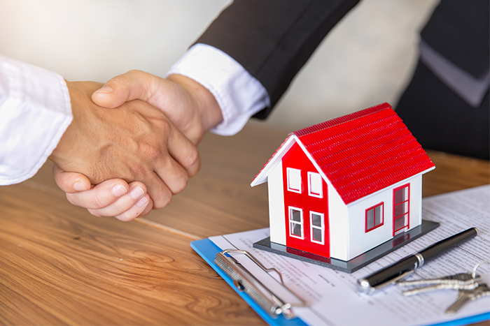 Handshake over a small model house